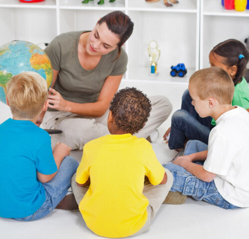 Group of kids learning from their preschool teacher
