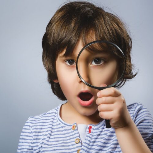 child looking through magnifying glass